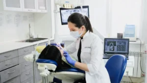 dentista fazendo uma limpeza dentária numa paciente que foi no consultório em camaçari