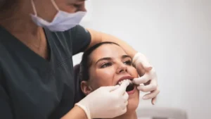 dentista cuidando dos dentes de uma pessoa que tem bruxismo e deseja colocar facetas de resina